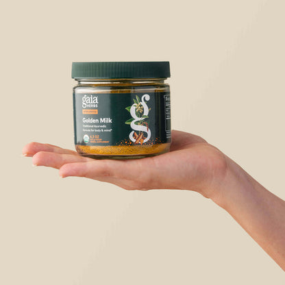 Golden Milk Bottle Held In A Person's Hand