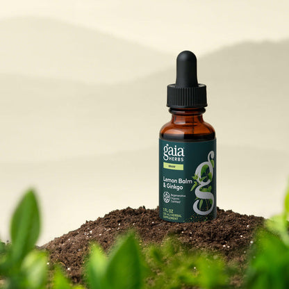 Gaia Herbs Lemon Balm & Ginkgo tincture bottle on a natural background with plants.