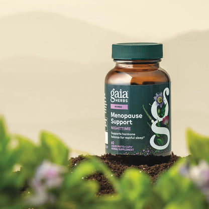 Gaia Herbs Menopause Support Nighttime 60 count bottle with plants in the foreground