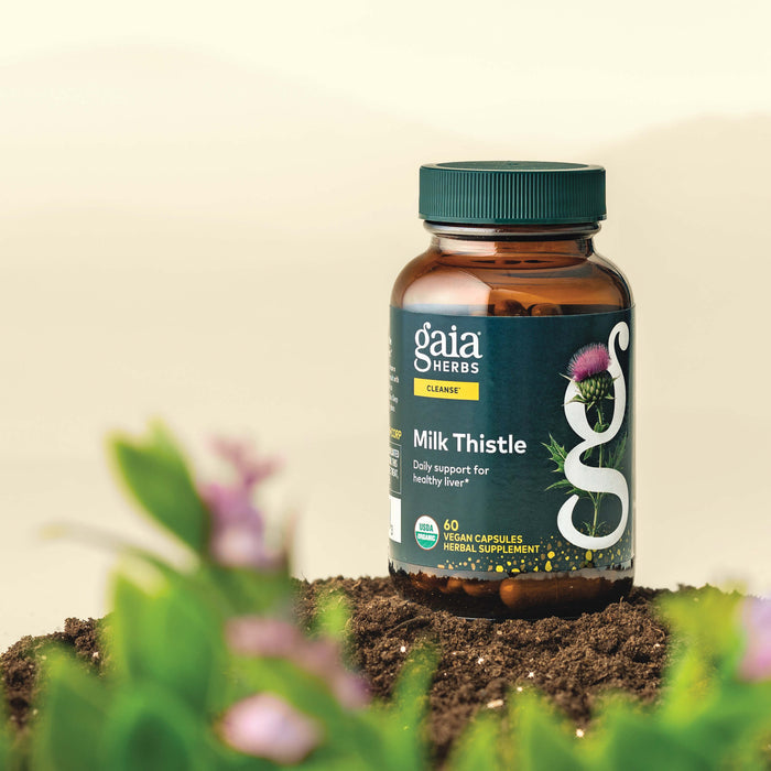 Gaia Herbs Milk Thistle 60 count supplement bottle on a natural background with plants.