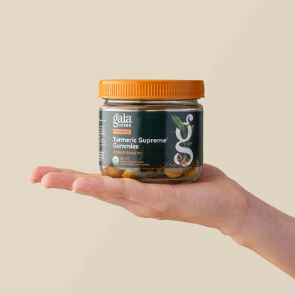 Turmeric Supreme Extra Strength Gummies 60 Count Bottle Held In A Person's Hand